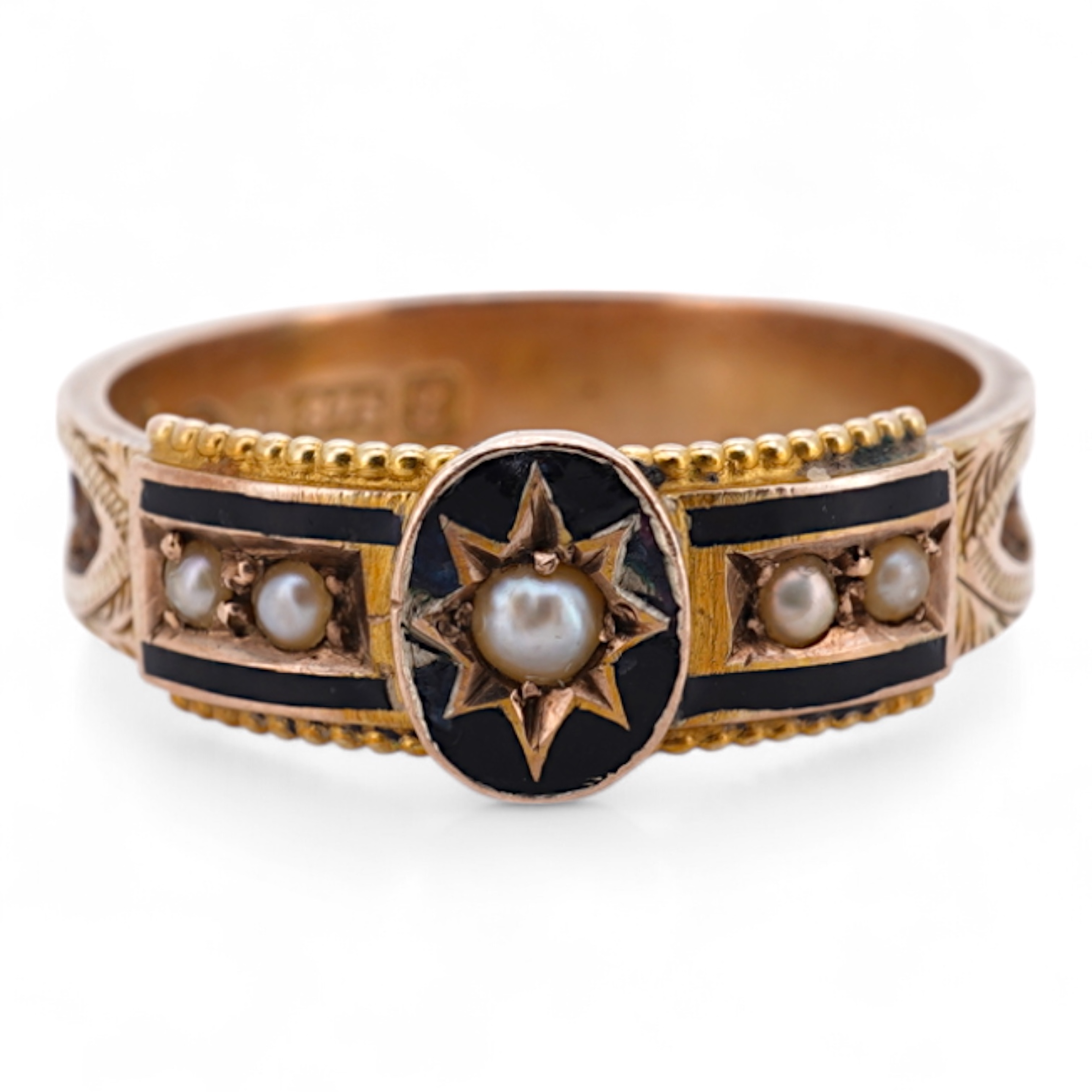 A George V 9ct gold, black enamel and seed pearl set mourning ring, the shank with panels of plaited hair, size O, gross weight 2.5 grams.